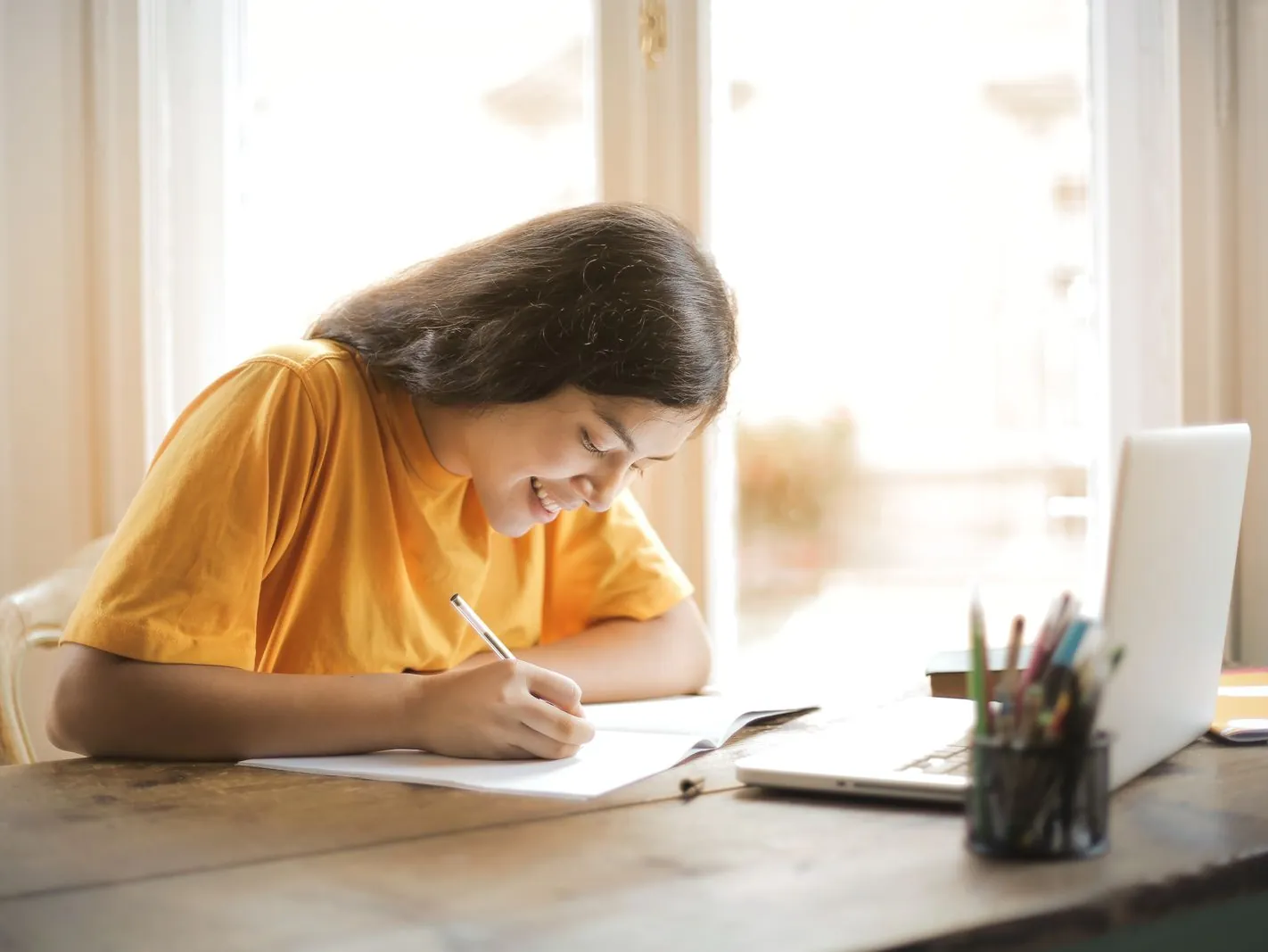 Content writer drafting a blog post with a laptop and notebook