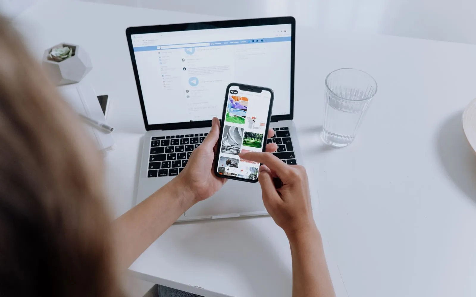 Marketer planning a content calendar on a phone and laptop