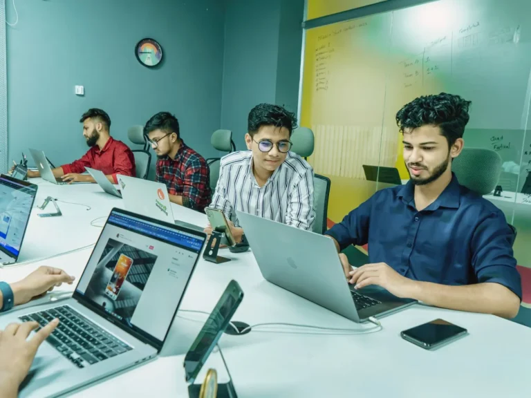 Digital marketing team working together on laptops