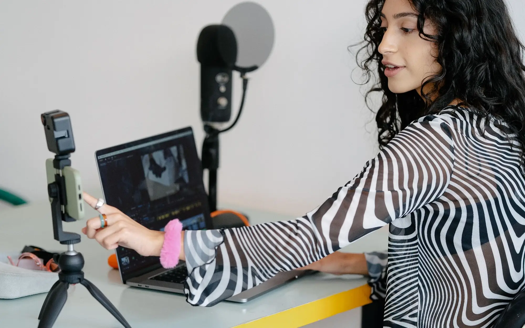 Creating LinkedIn post content with a phone on a tripod and a laptop