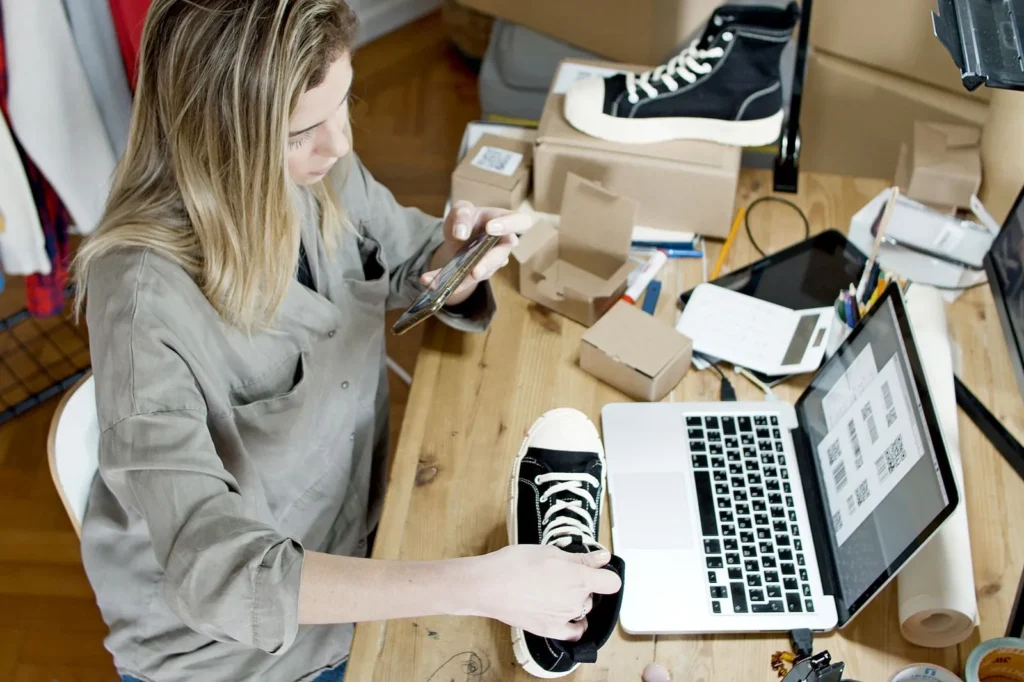 Seller photographing shoes for an online store listing